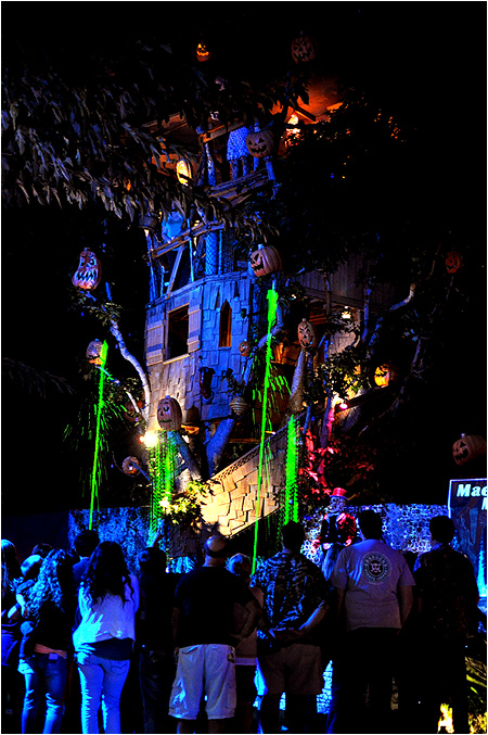 Bubbling cauldrons burst green liquids in front of a giant treehouse with ornate jack-o-lanterns flashing all over it.
